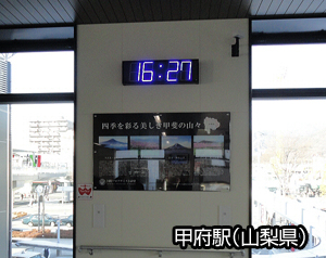 駅内の広告ポスターの上に設置した時計